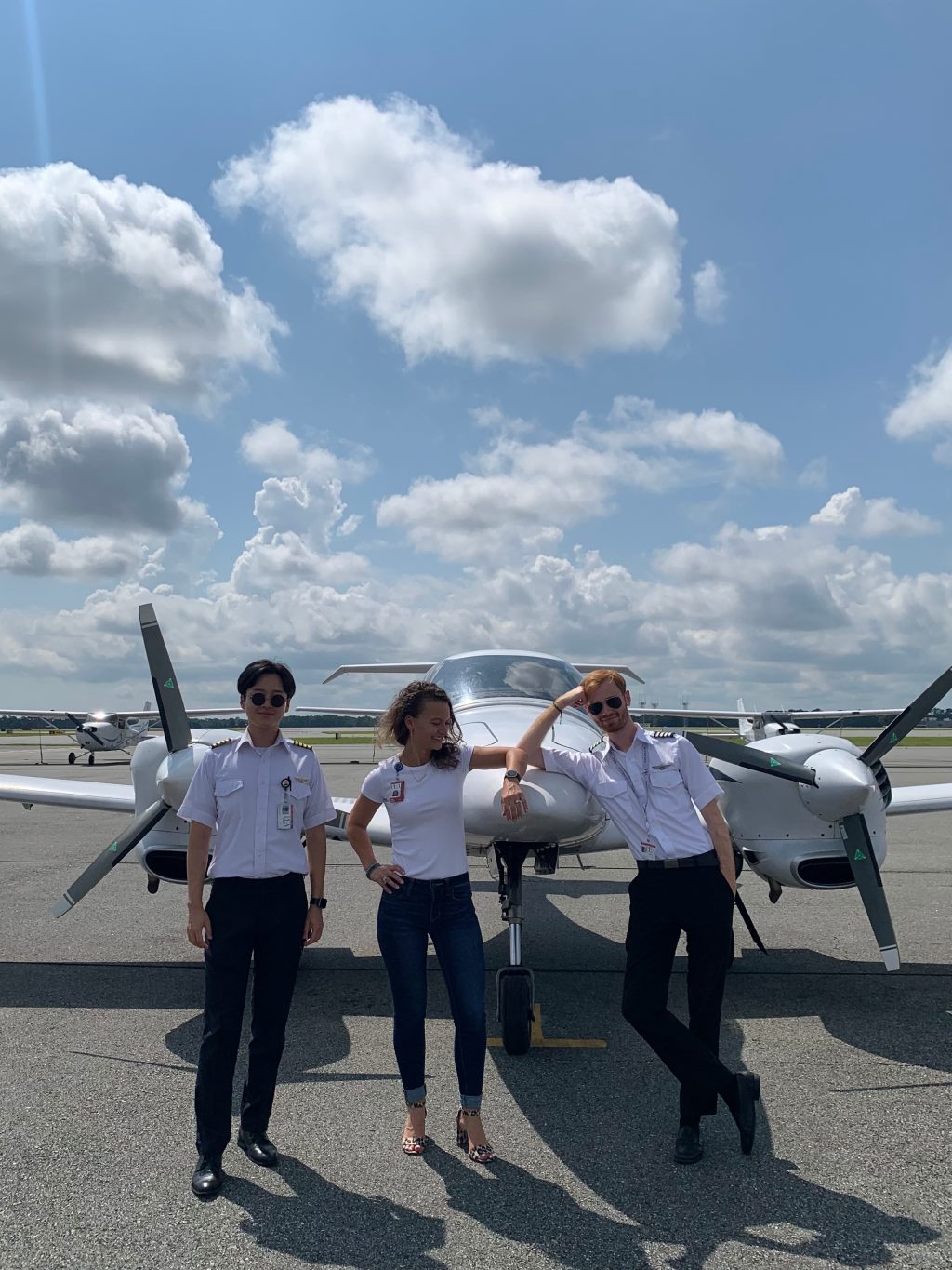 Adrien(R) leaning on DA42 with Amelie Coleman, Admissions Manager in center, with another instructor on the R.