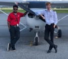 Adrien after receiving his PPL, posing against Cessna with instructor on lefthand side of Cessna with hand on prop