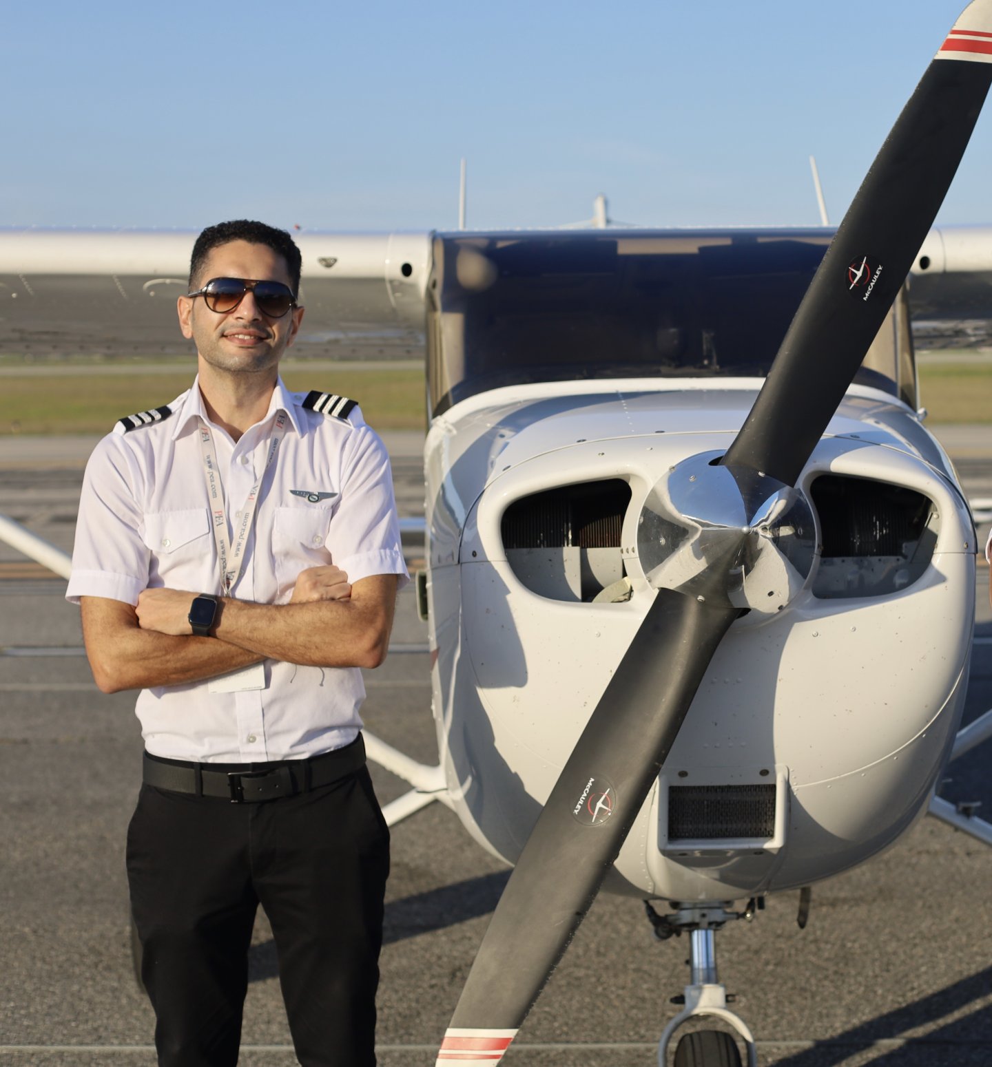 Peter Gad to the right of PEA Cessna 172 Prop smiling with his arms crossed