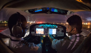 medium detailed shot of 2 pilots in cockpit during night, highlighting G1000 Avionics