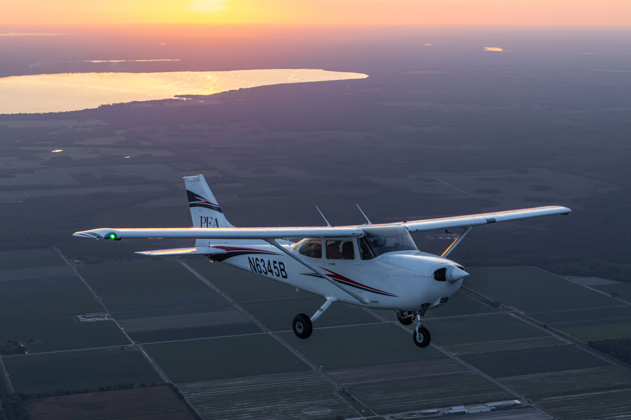 PEA Cessna N6345B from formation photoshoot over field during sunset