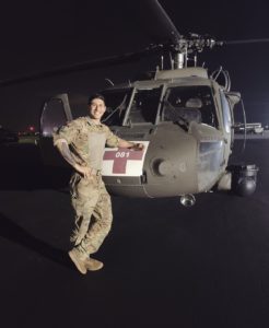 Andrew Herber standing in front of a Blackhawk in full military uniform