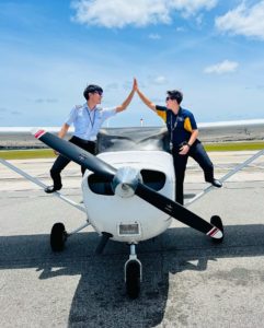 Frans on the right with student on the left high fiving on a Cessna 172 as a completion photo