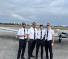 group shot of Omar (far right) with friends in front of Piper Seneca PA34