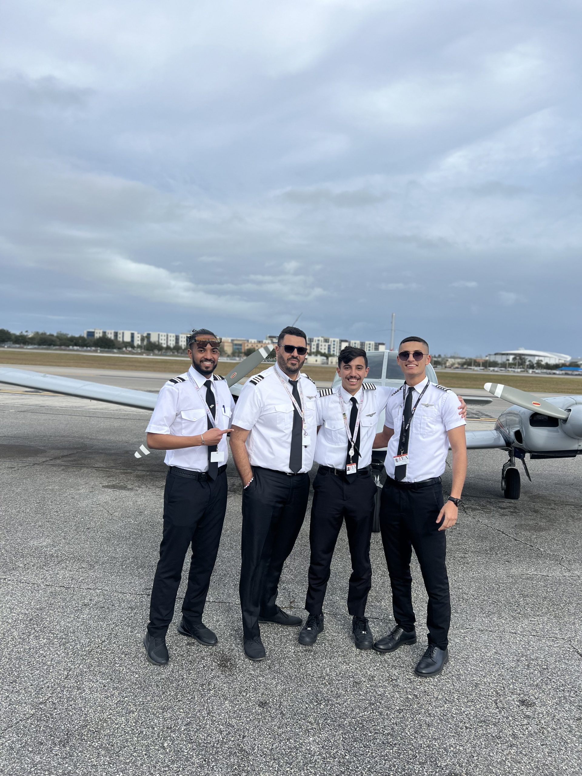 group shot of Omar (far right) with friends in front of Piper Seneca PA34