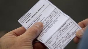 man holding a third class medical certificate