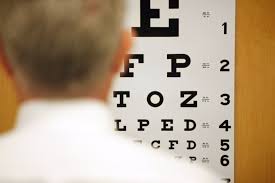 Man standing in front of vision test chart