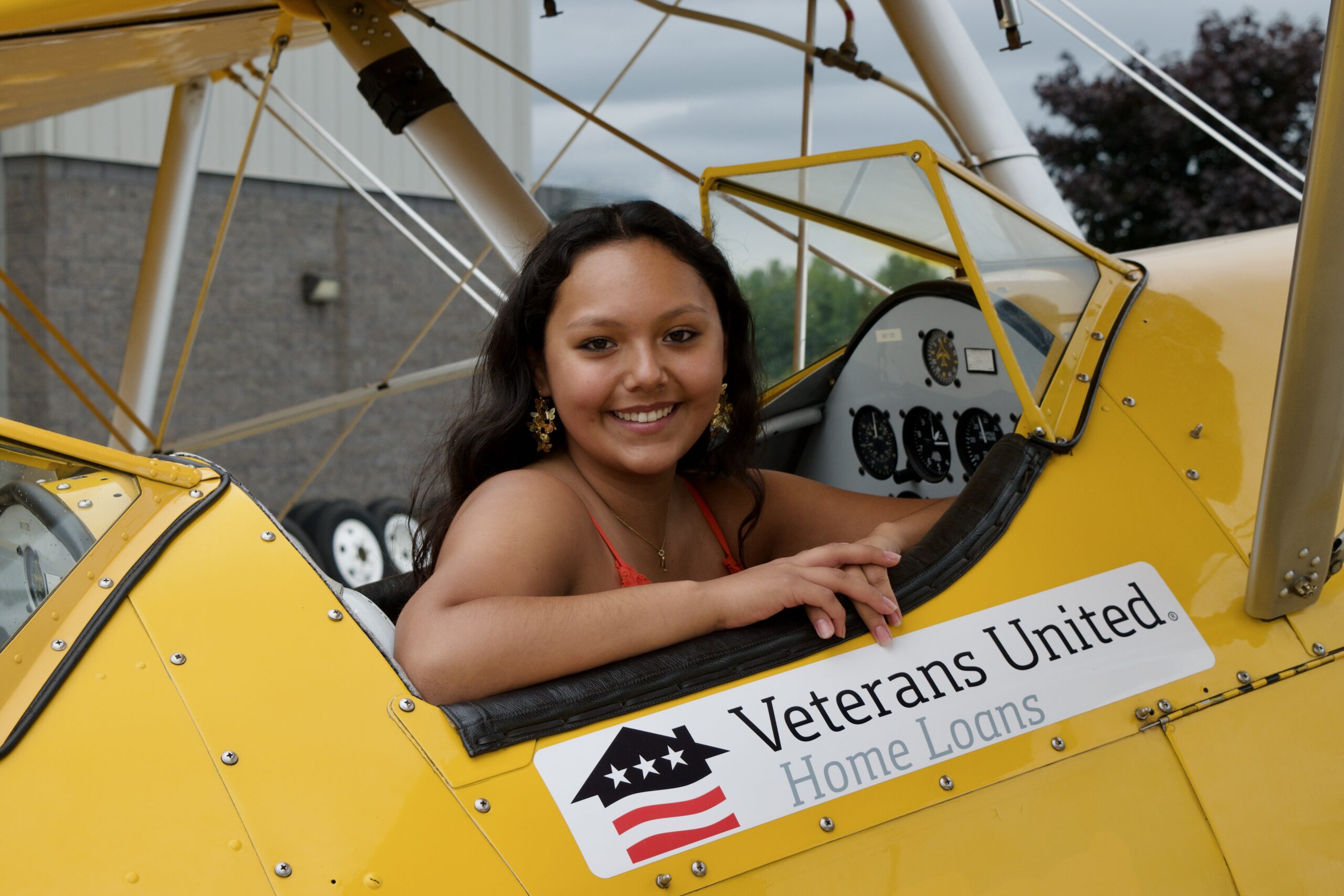 Lainie Zinser sitting in yellow aircraft looking over shoulder and smiling