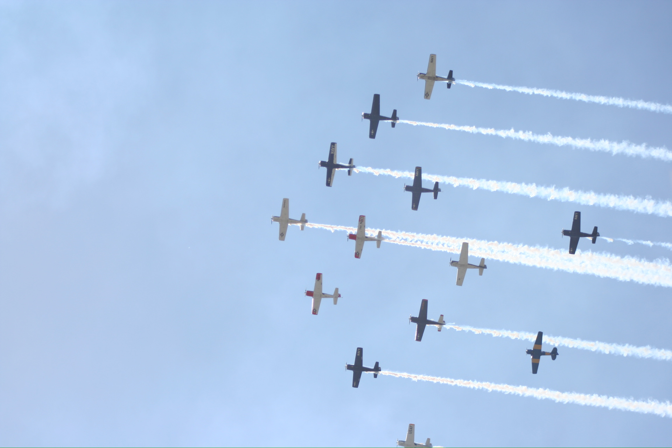 planes in the sky during daily airshow at EAA Oshkosh AirVenture