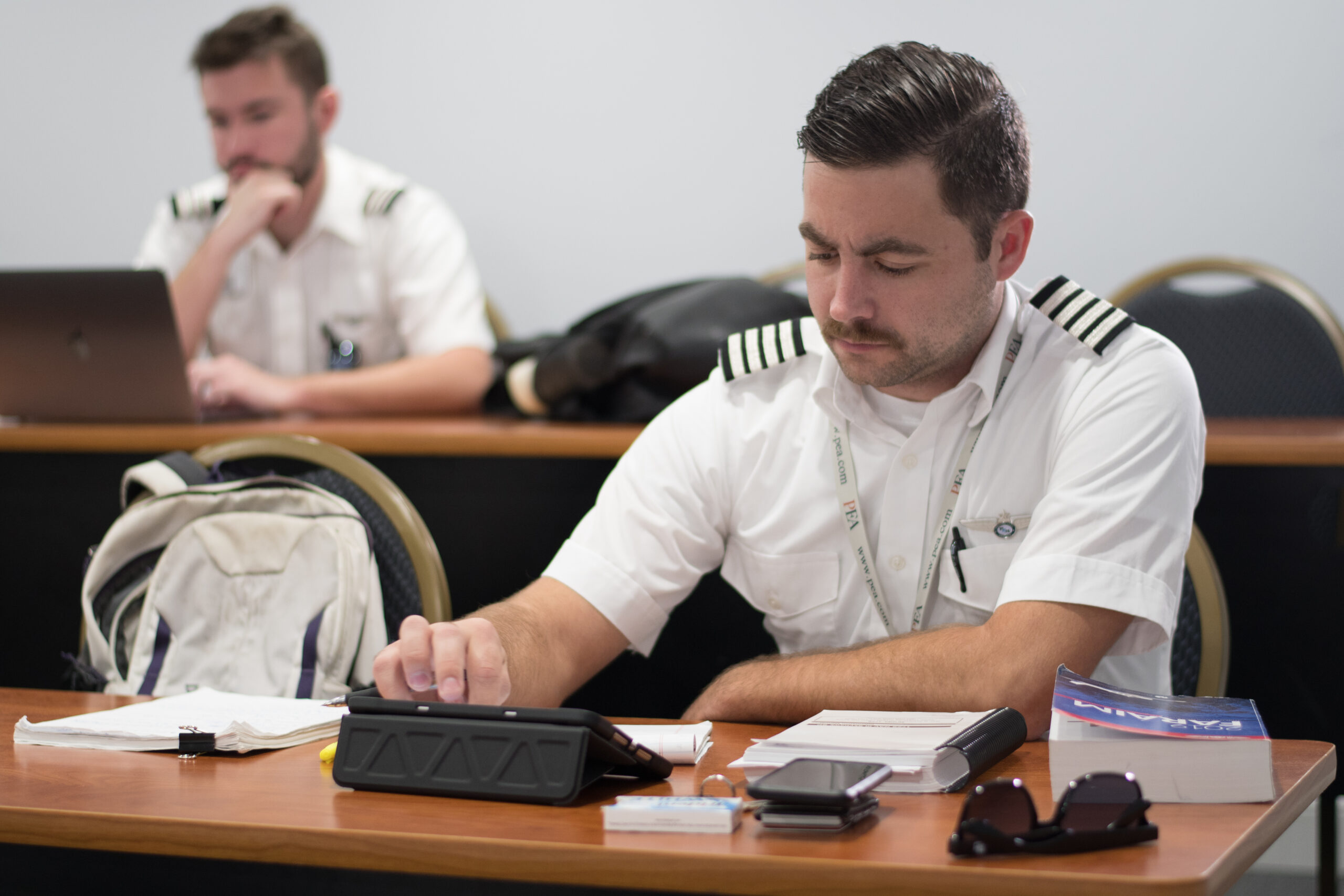 Student pilot reviewing coursework and calculations during an aviation ground school training session.